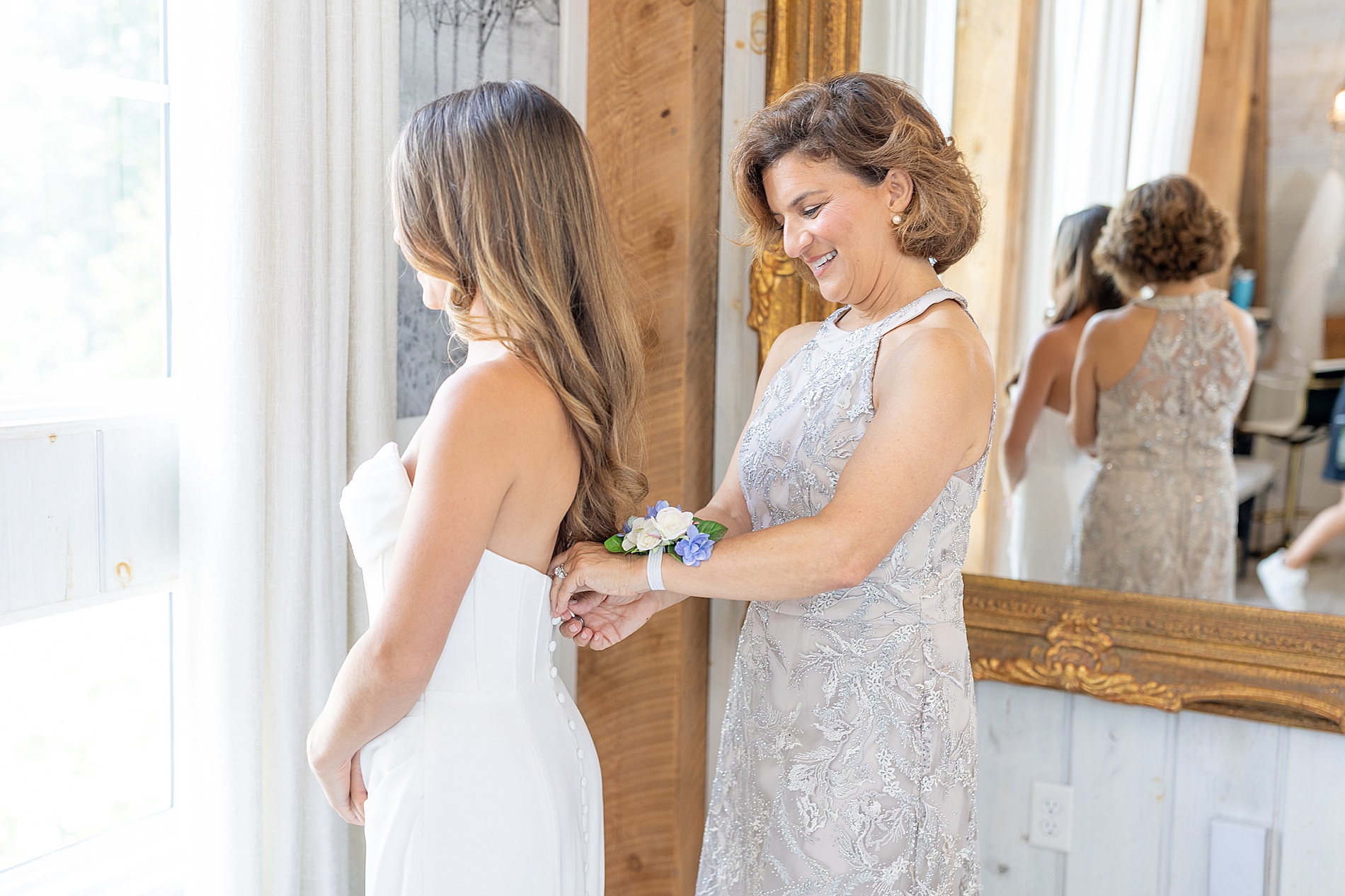 bride getting into wedding dress inside bridal suite 