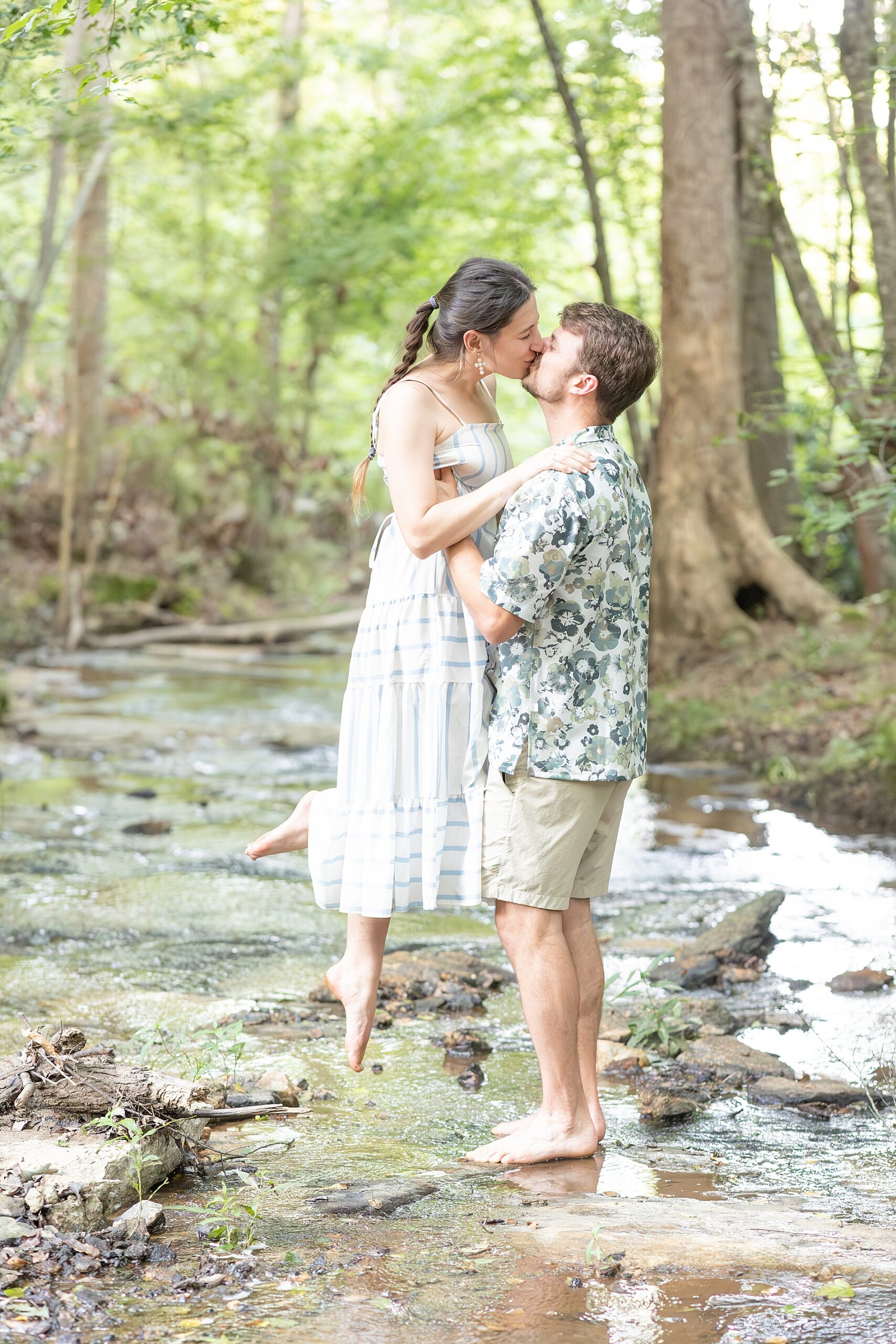 couple kiss during family lifestyle session outdoors