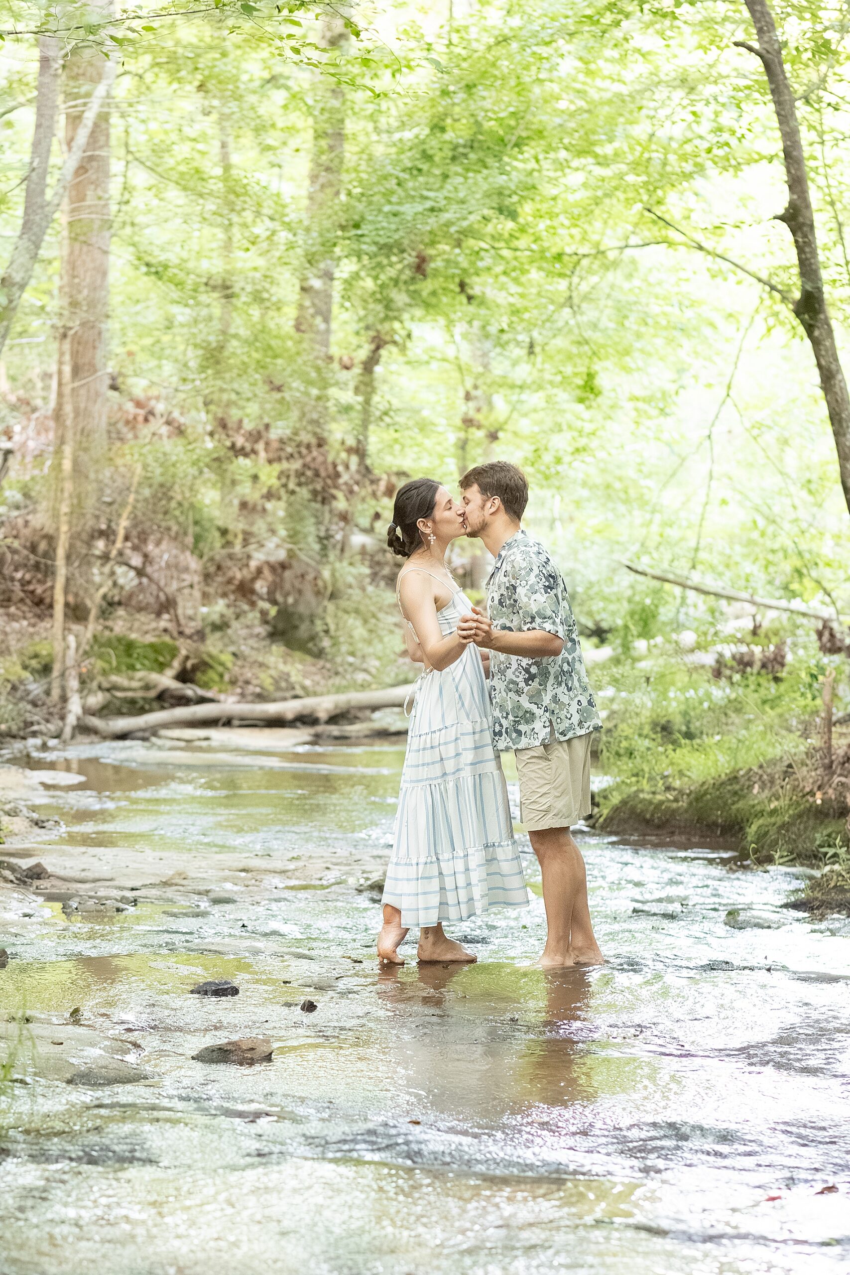 couple kiss while walking in creek