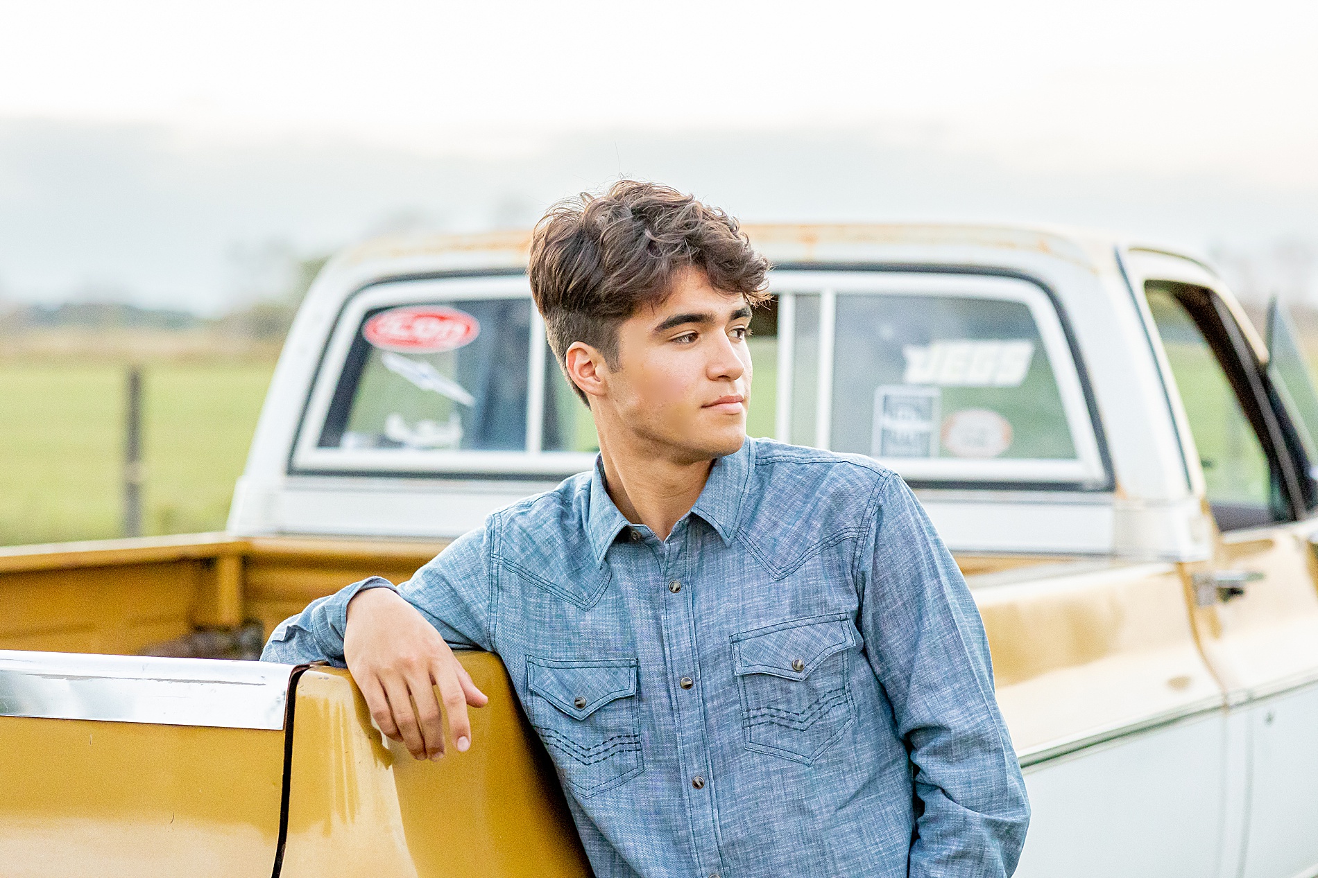 senior leans against his truck