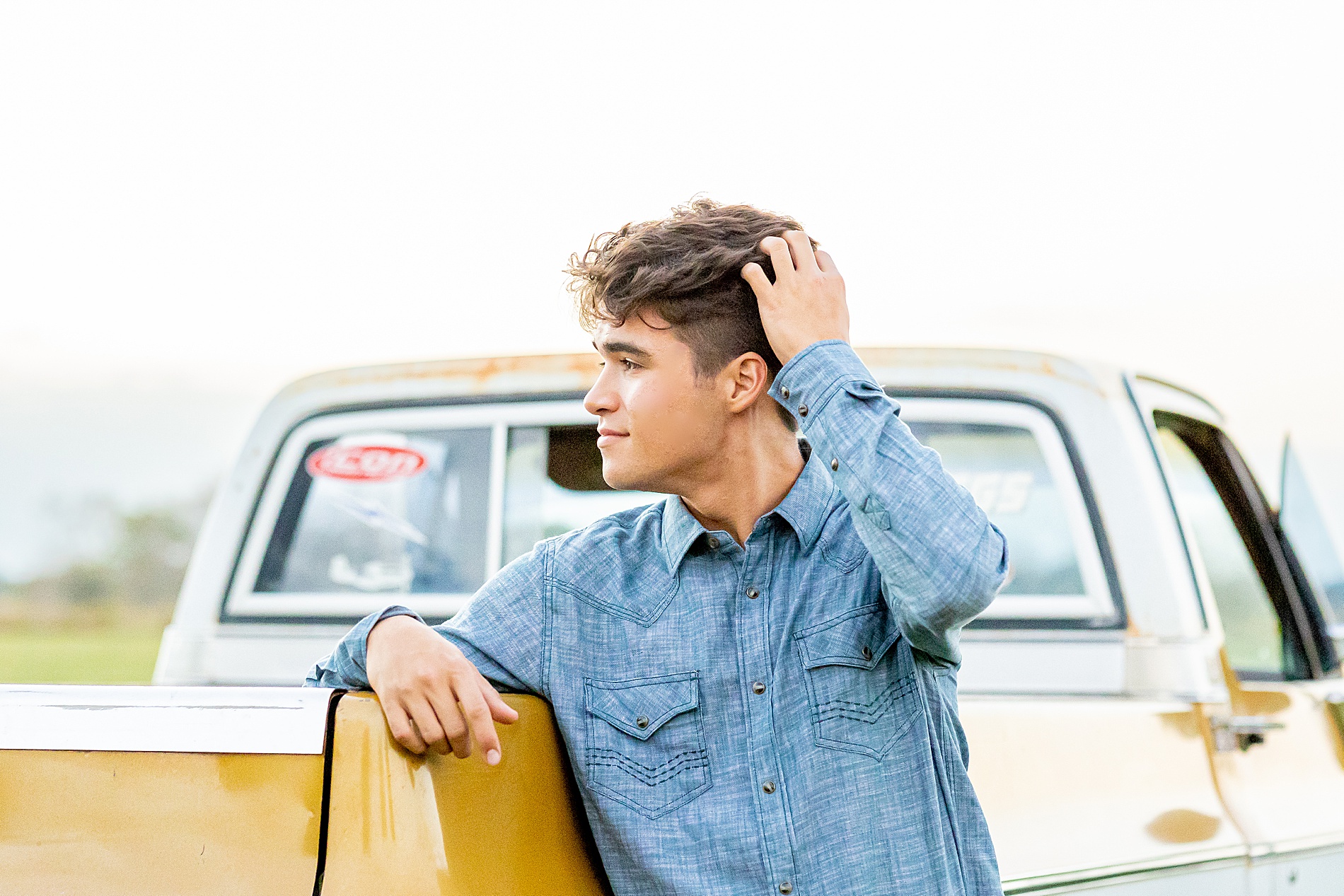 senior boy leans against truck