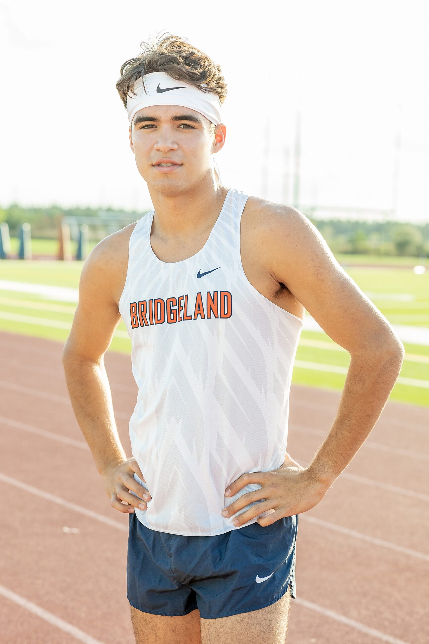 senior portraits at track to showcase his track scholarship 