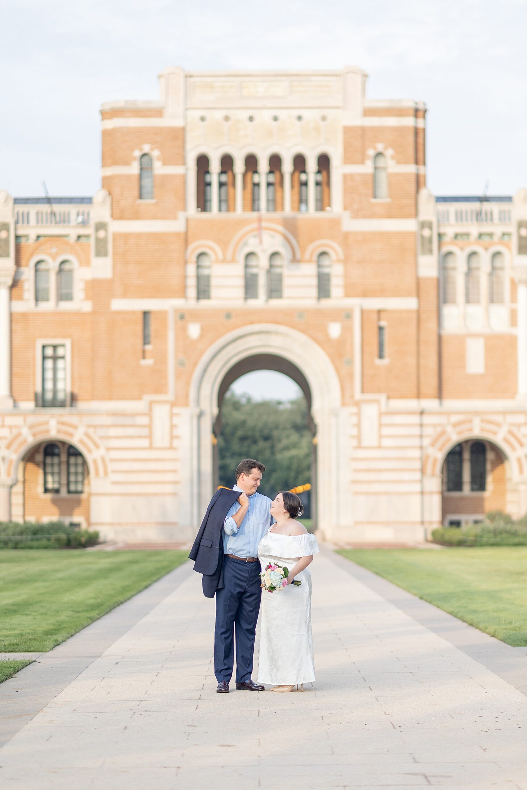 couple outside of archway of Rice University