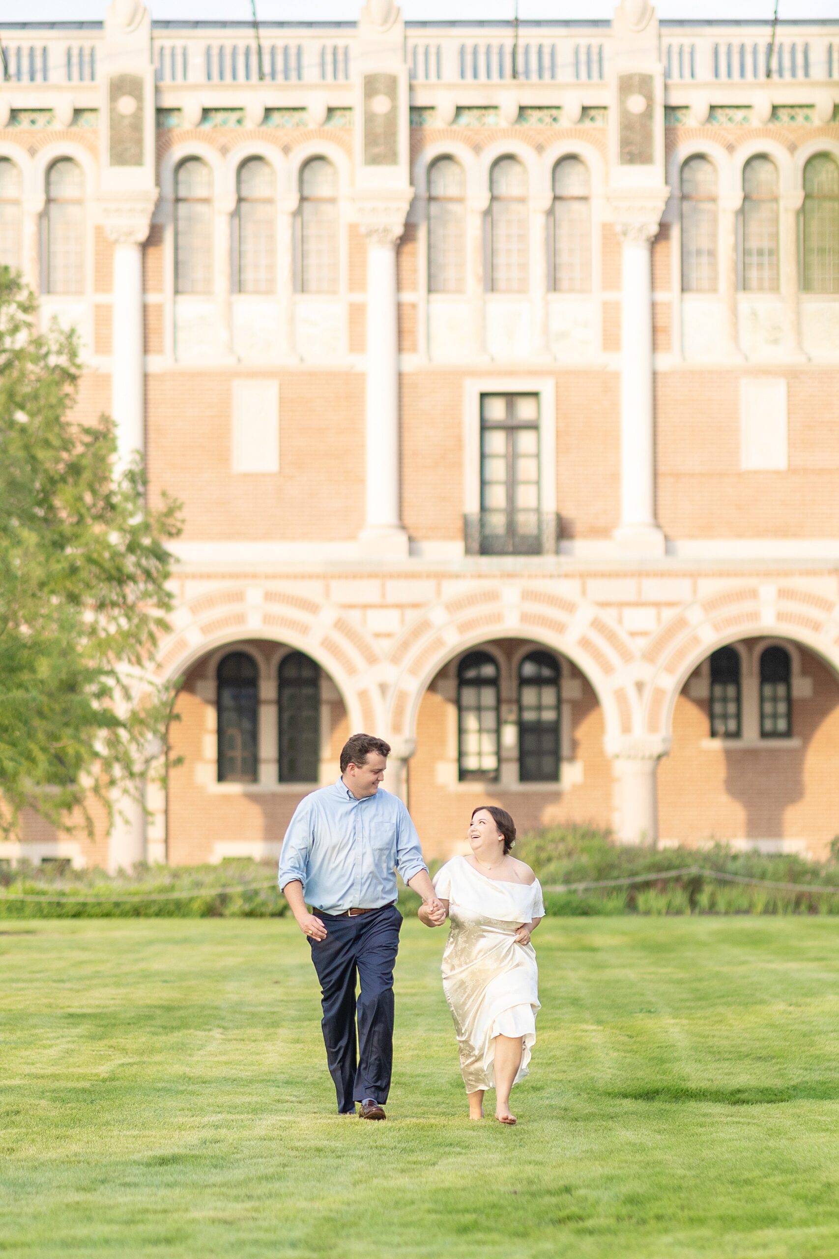 couple hold hands as they walk across the lawn