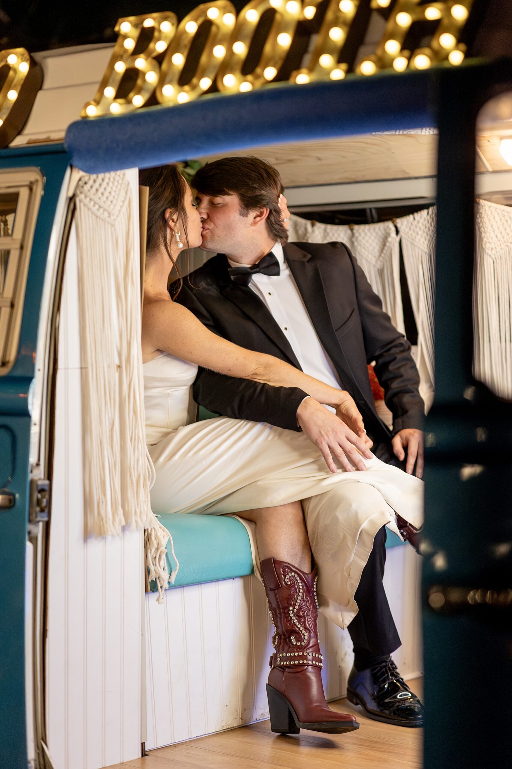 bride and groom kiss in rv photobooth