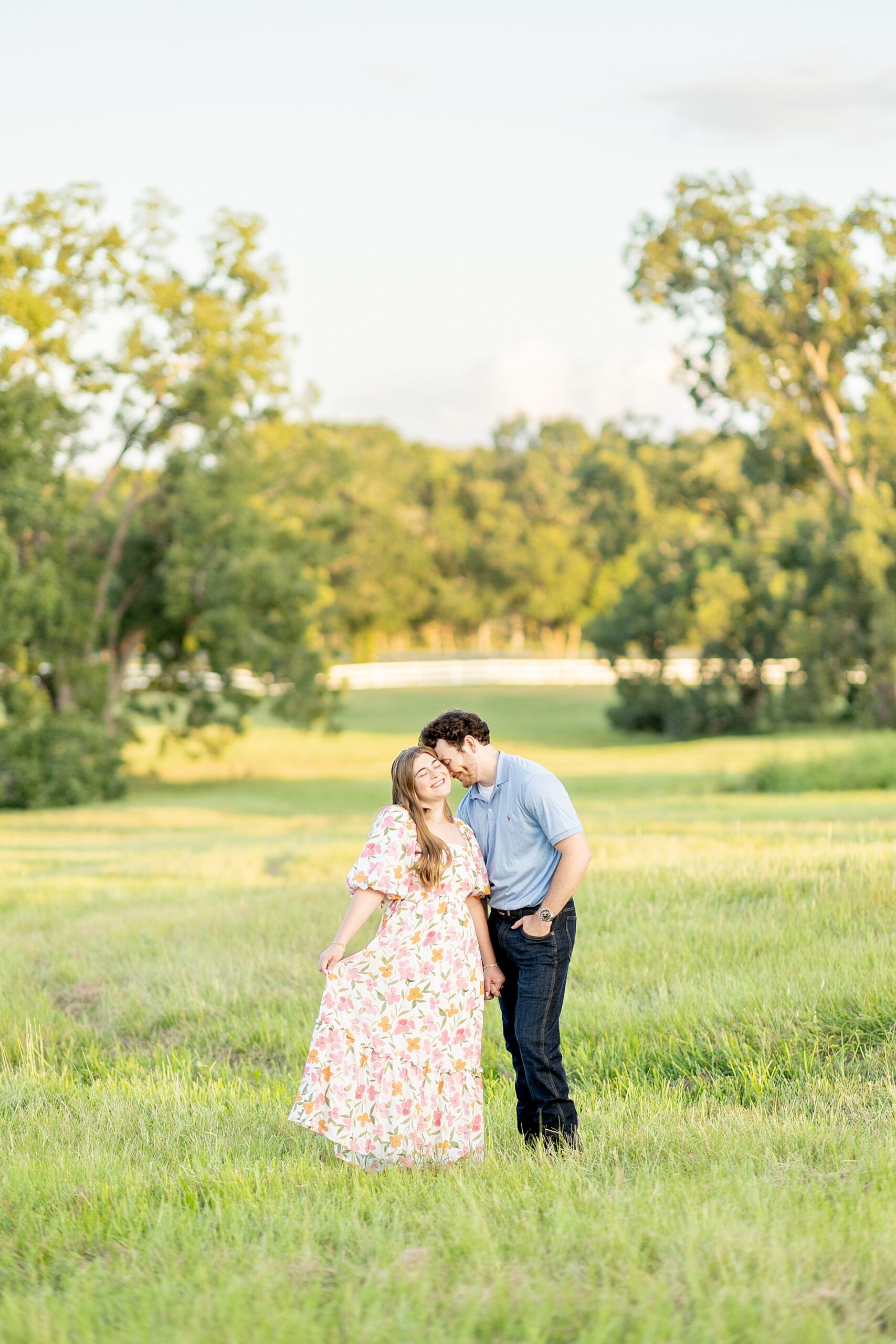 couple kiss in field at Deep In The Heart Farms during summer engagement in Texas