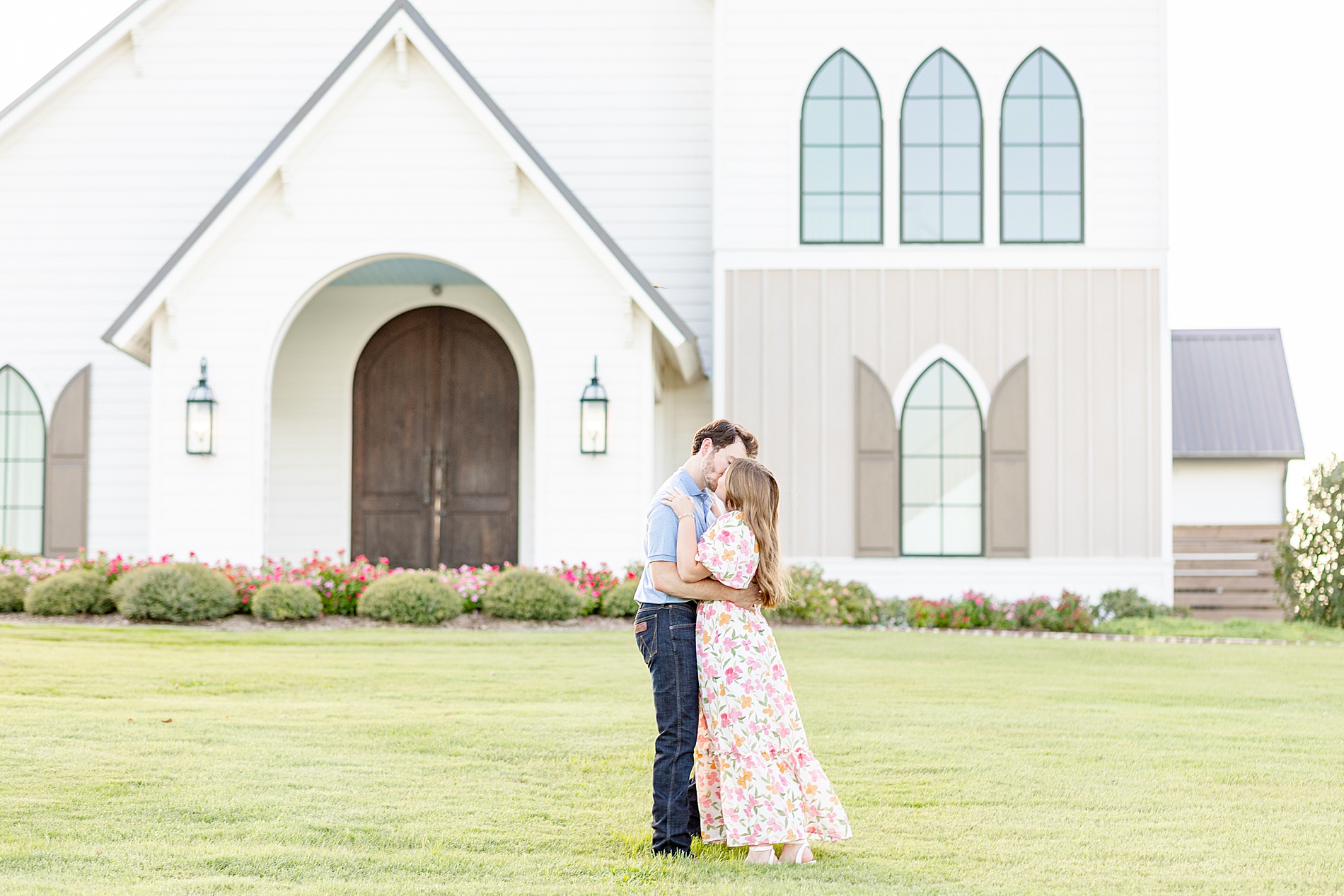 Houston engagement photographer photographs engaged couple in front of chapel at Deep In The Heart Farms
