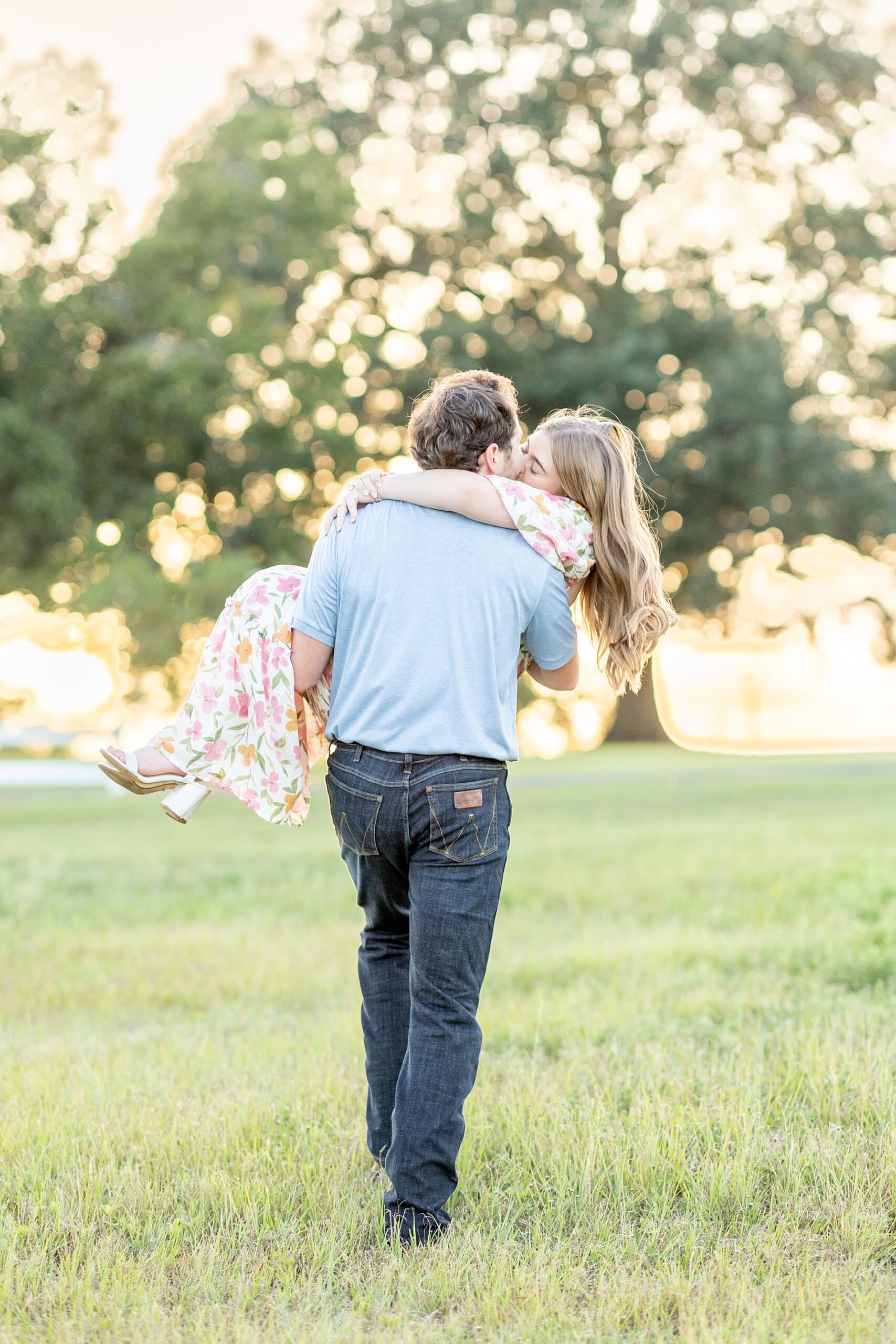 romantic engagement photos of man carrying fiancé at Deep In The Heart Farms