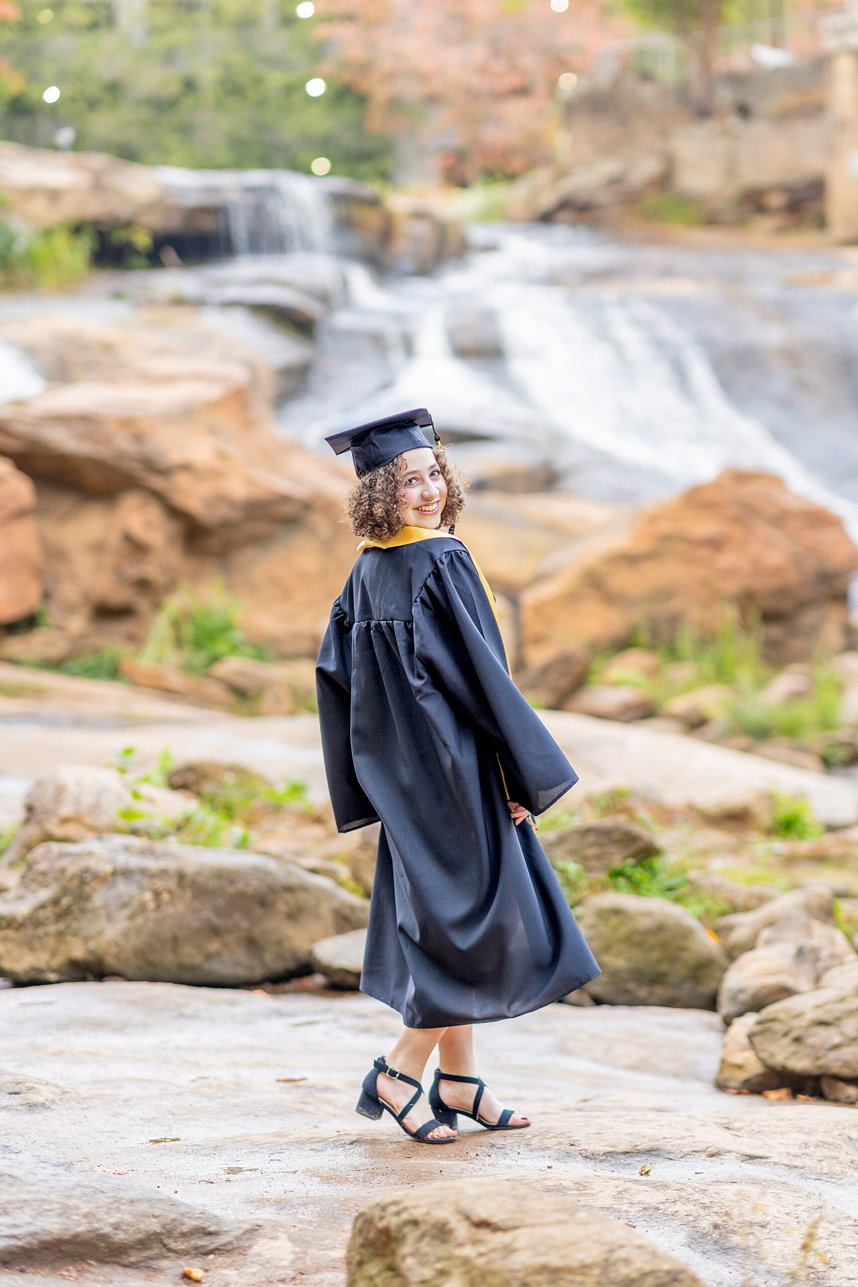 senior in cap and gown during graduation photos