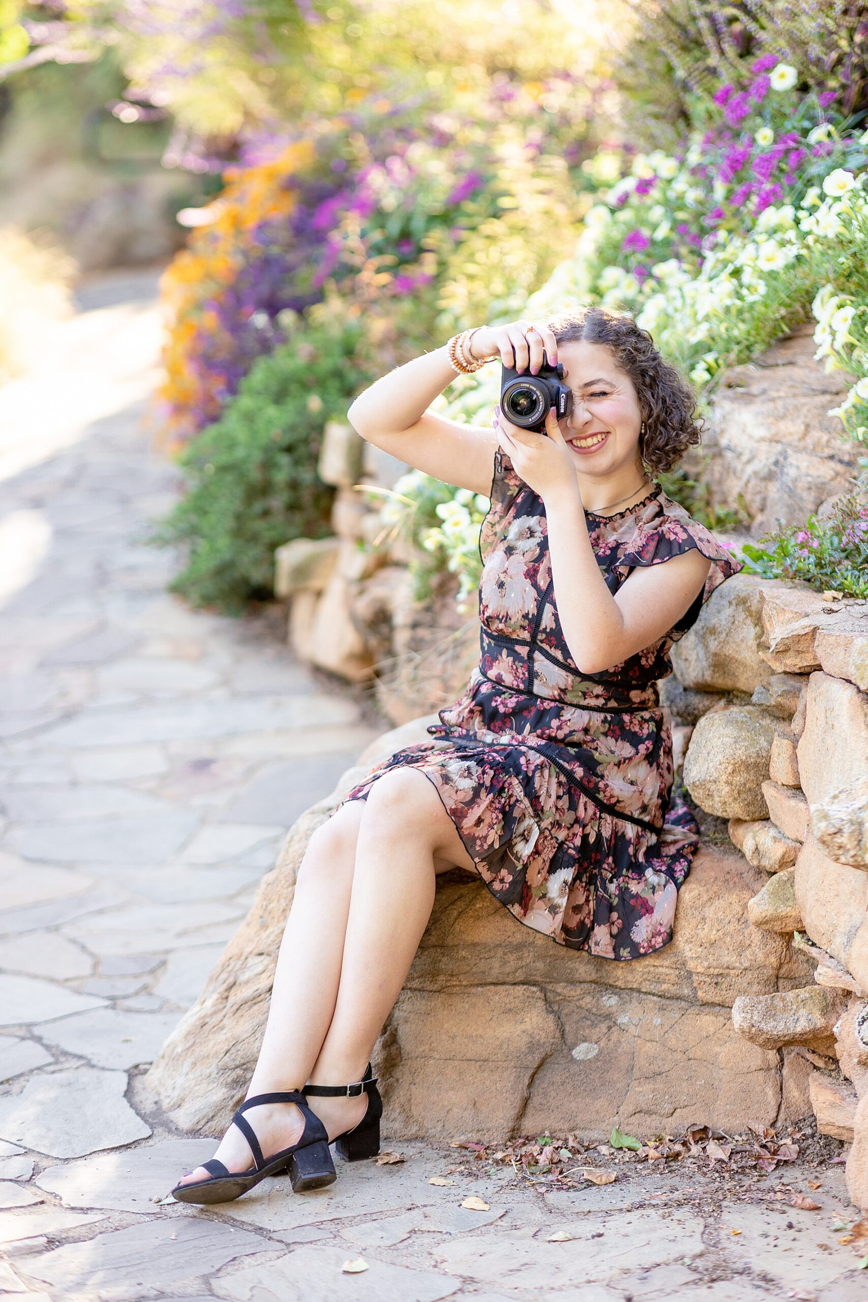 high school graduate holds her camera during senior session