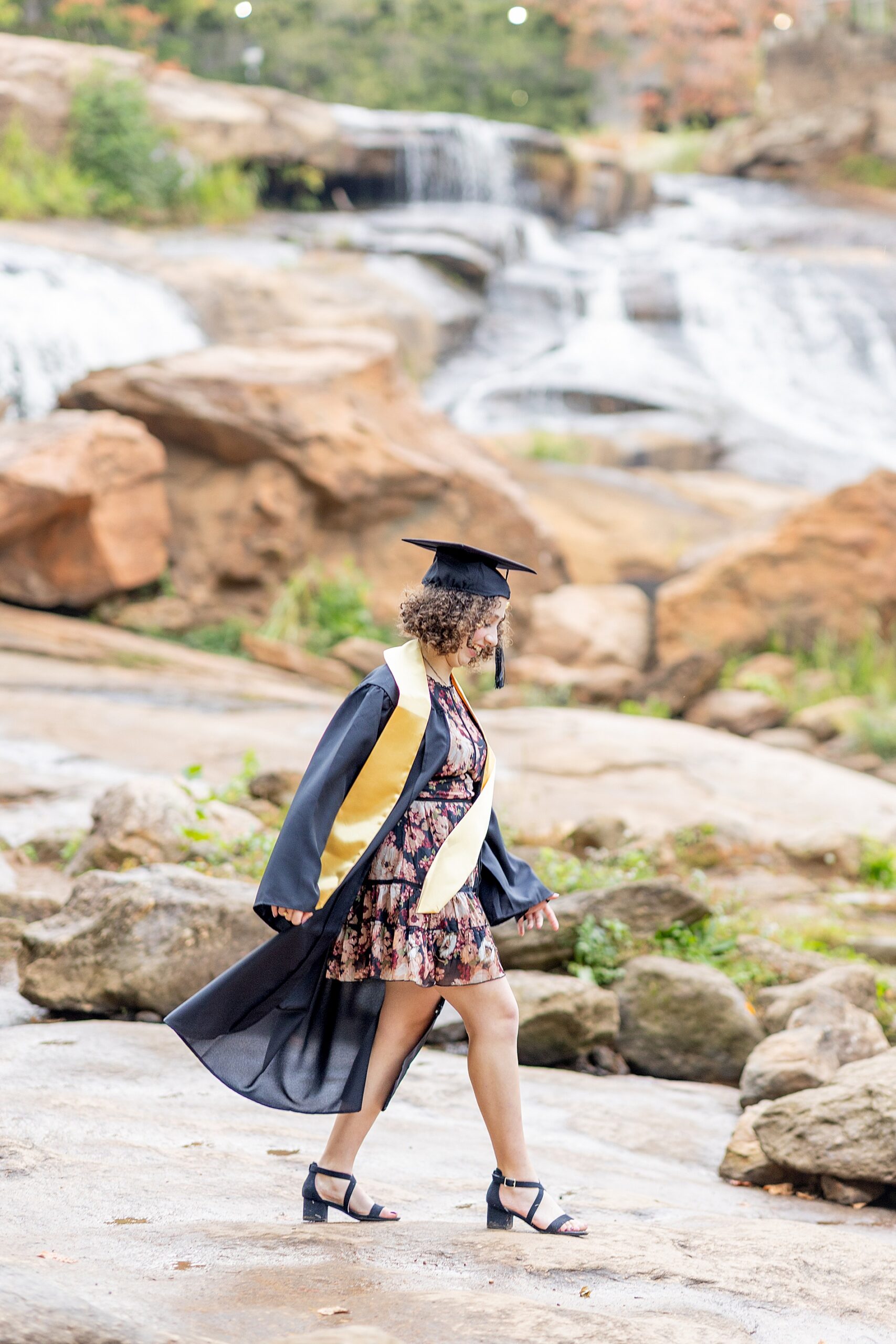 senior walks across rocks