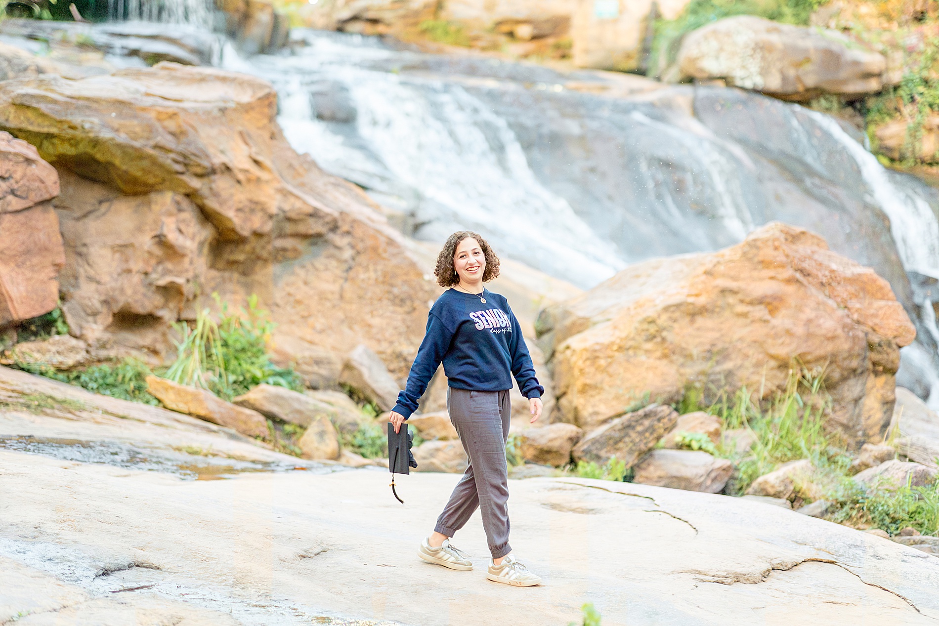 senior portraits walk by waterfall at Falls Park
