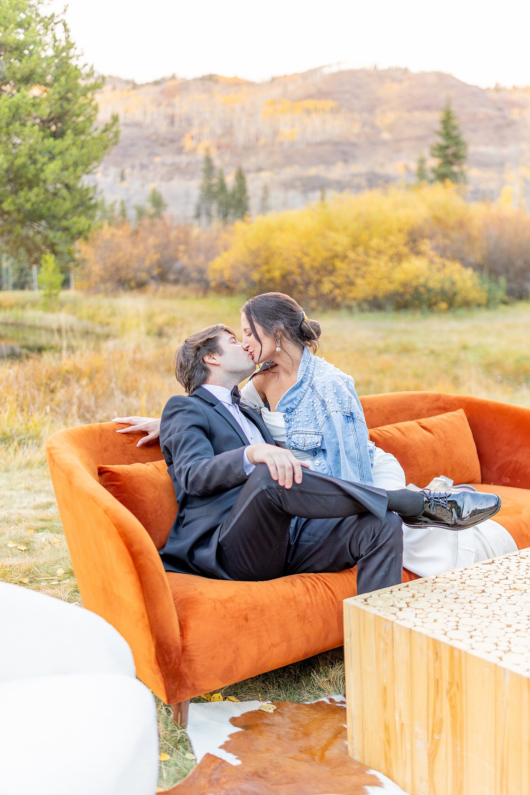 newlyweds kiss as they sit on couch outside