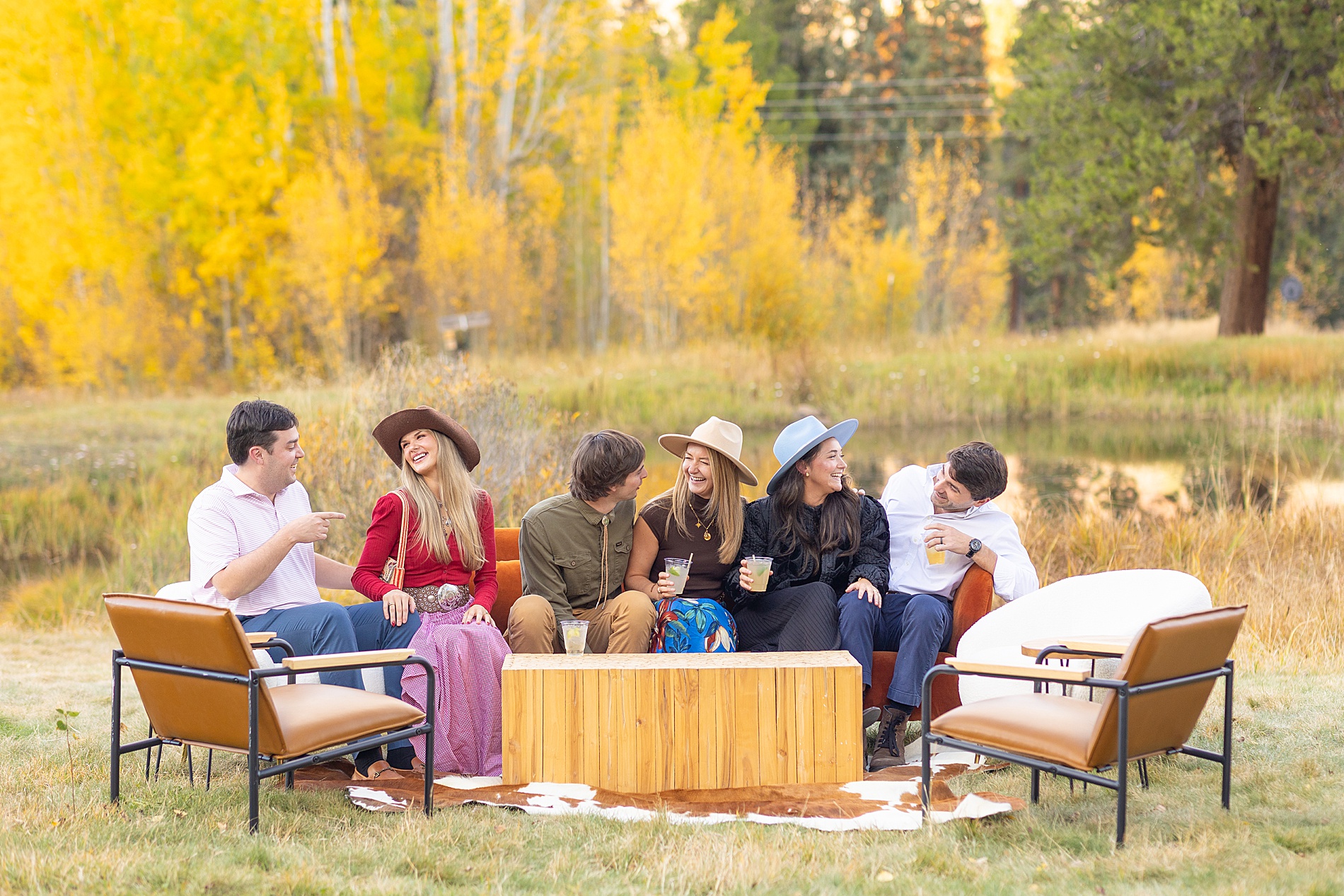 wedding guests sit on cozy seating outside during wedding welcome party