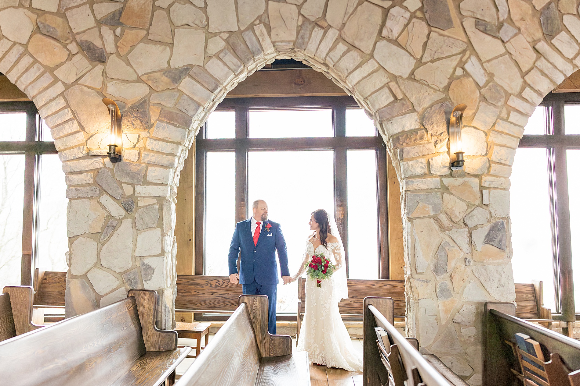 couple hold hands inside chapel