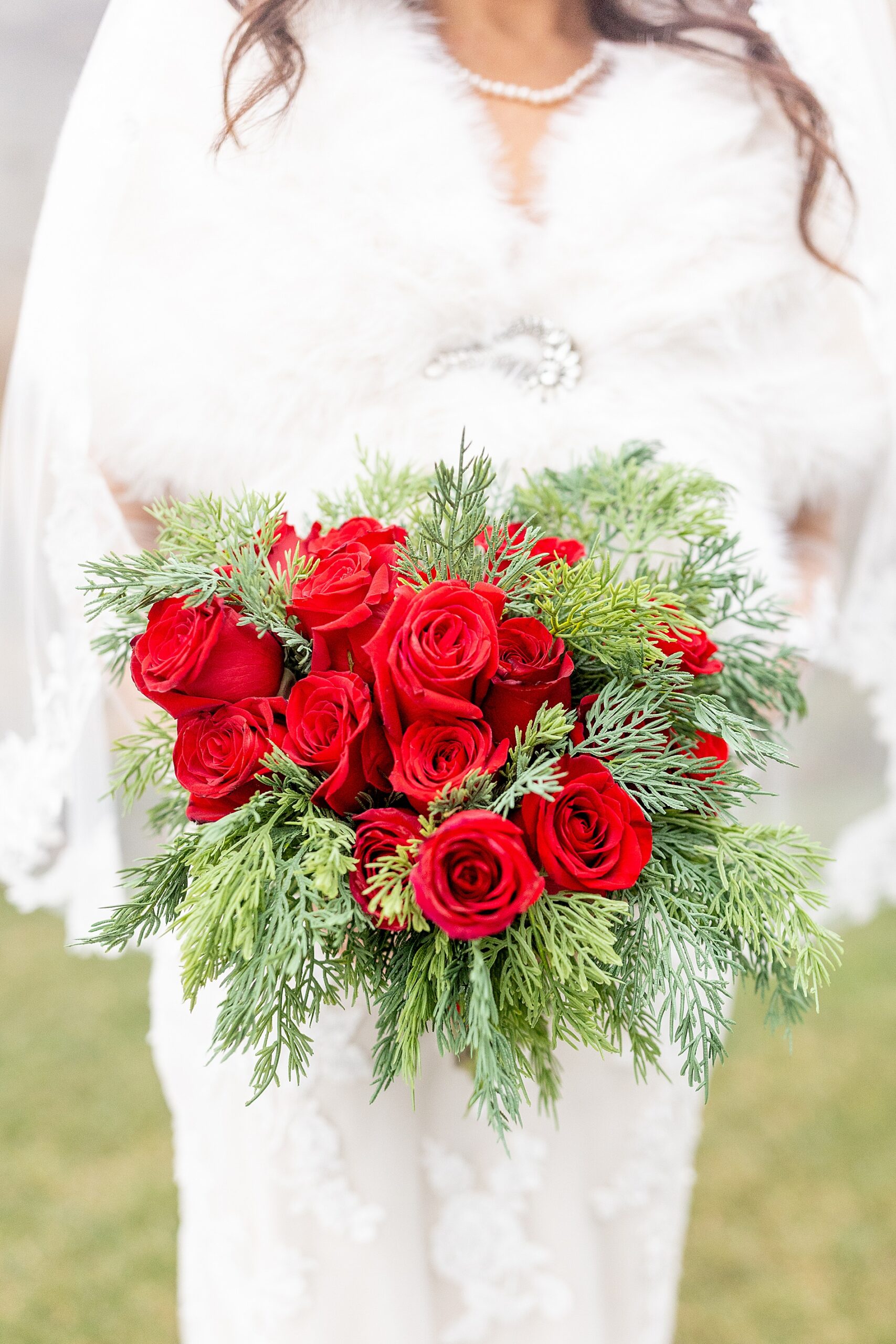Christmas wedding bouquet with red roses and springs of pine 