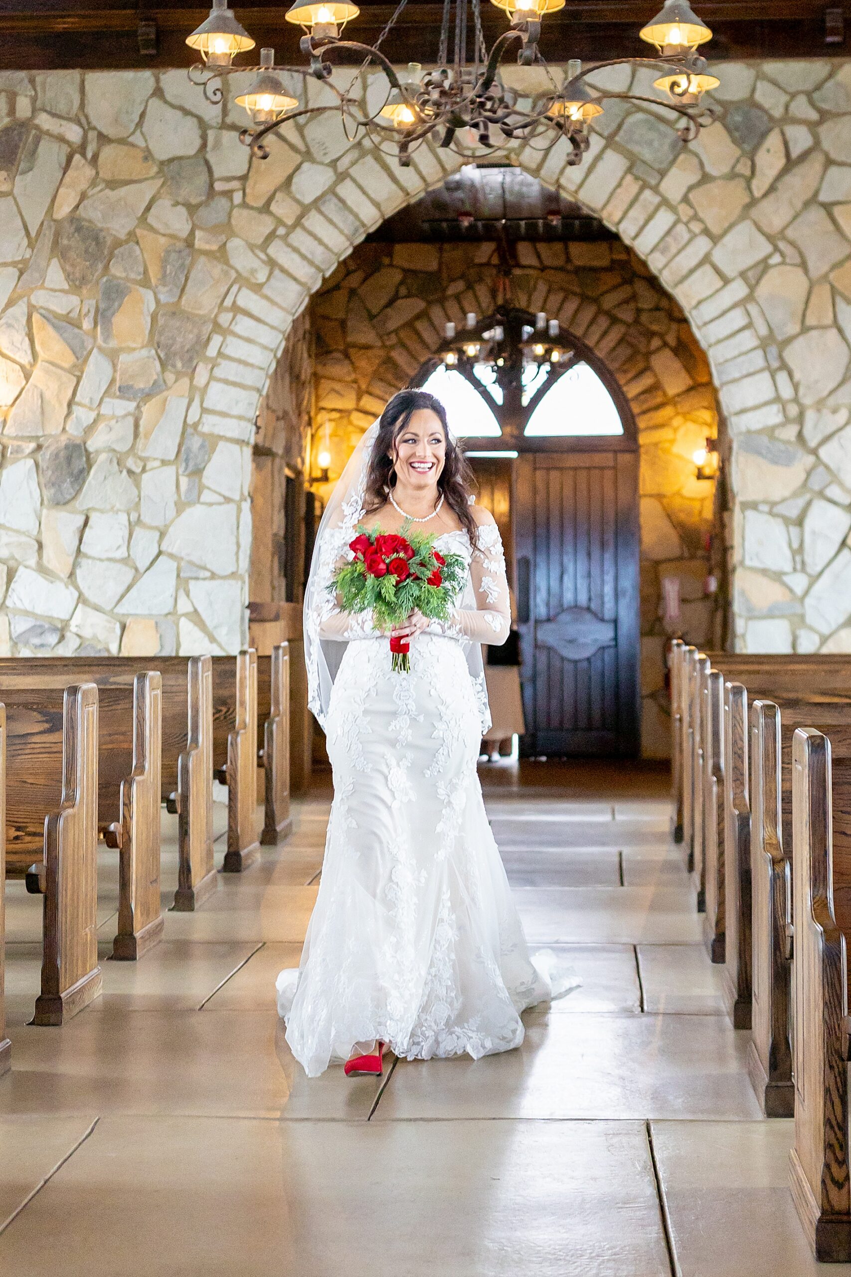 bride carrying bouquet of red roses
