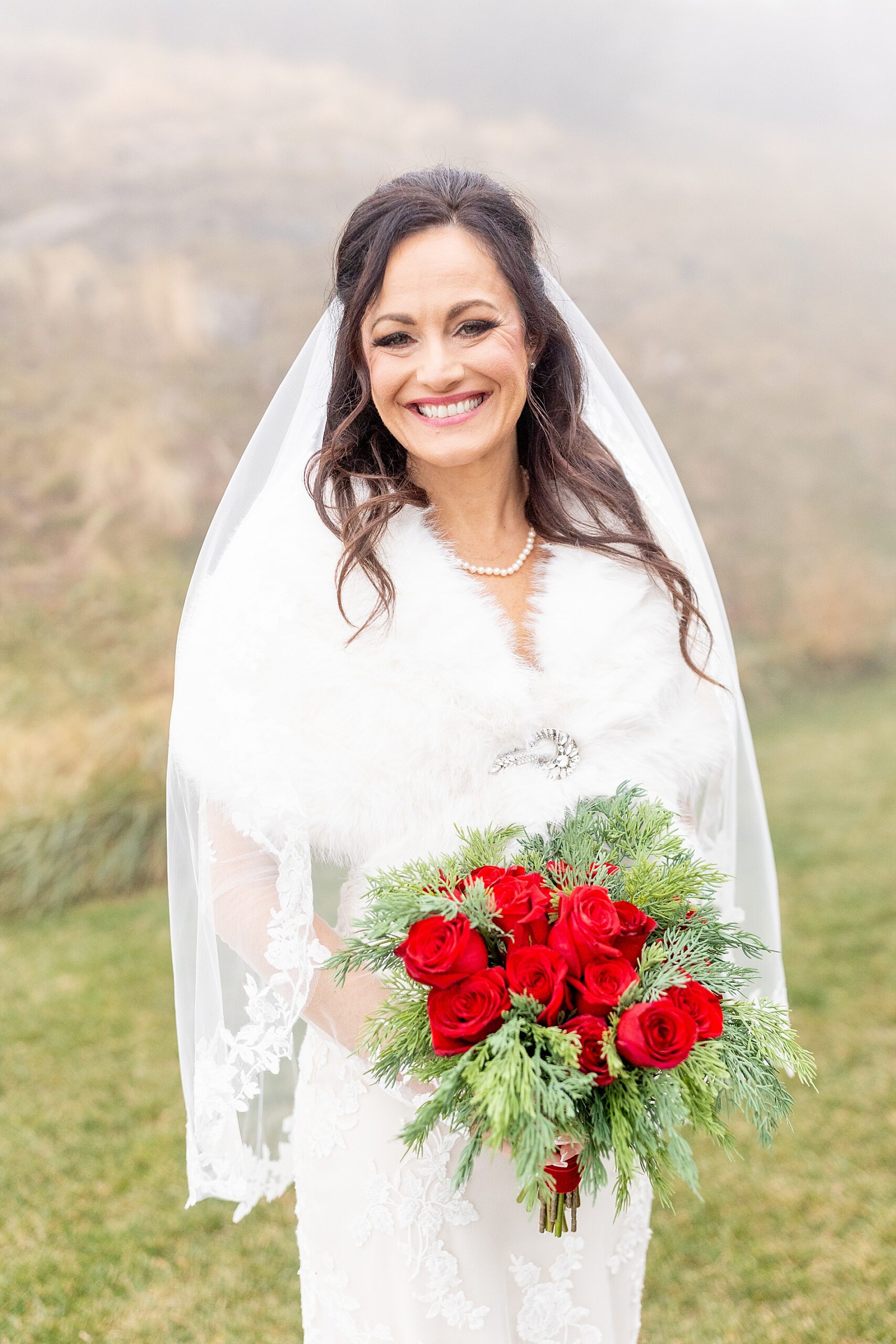 bride on hilltop in dress and festive wedding bouquet 