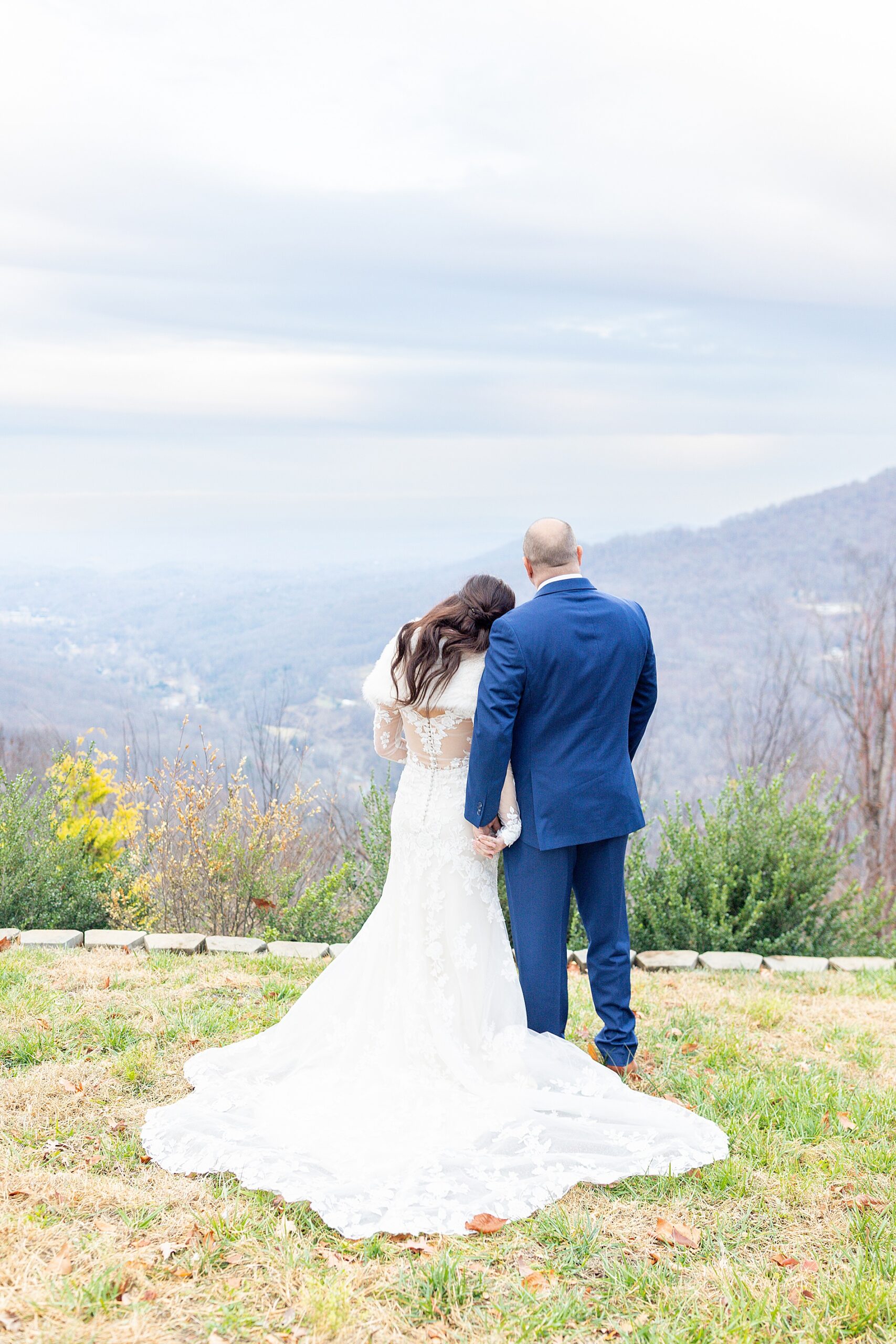 newlyweds look out over the mountains. 