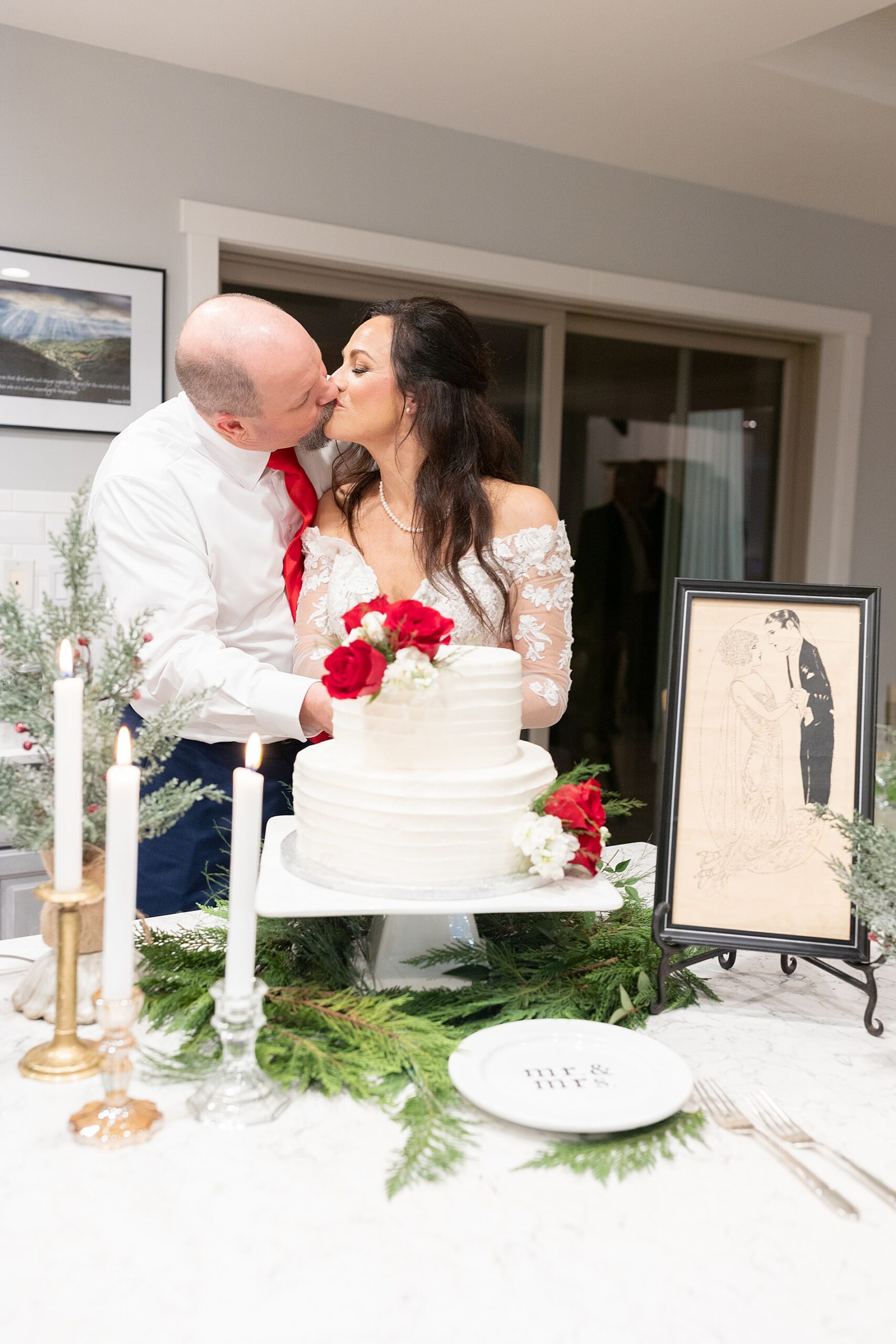 newlyweds kiss while cutting wedding cake 