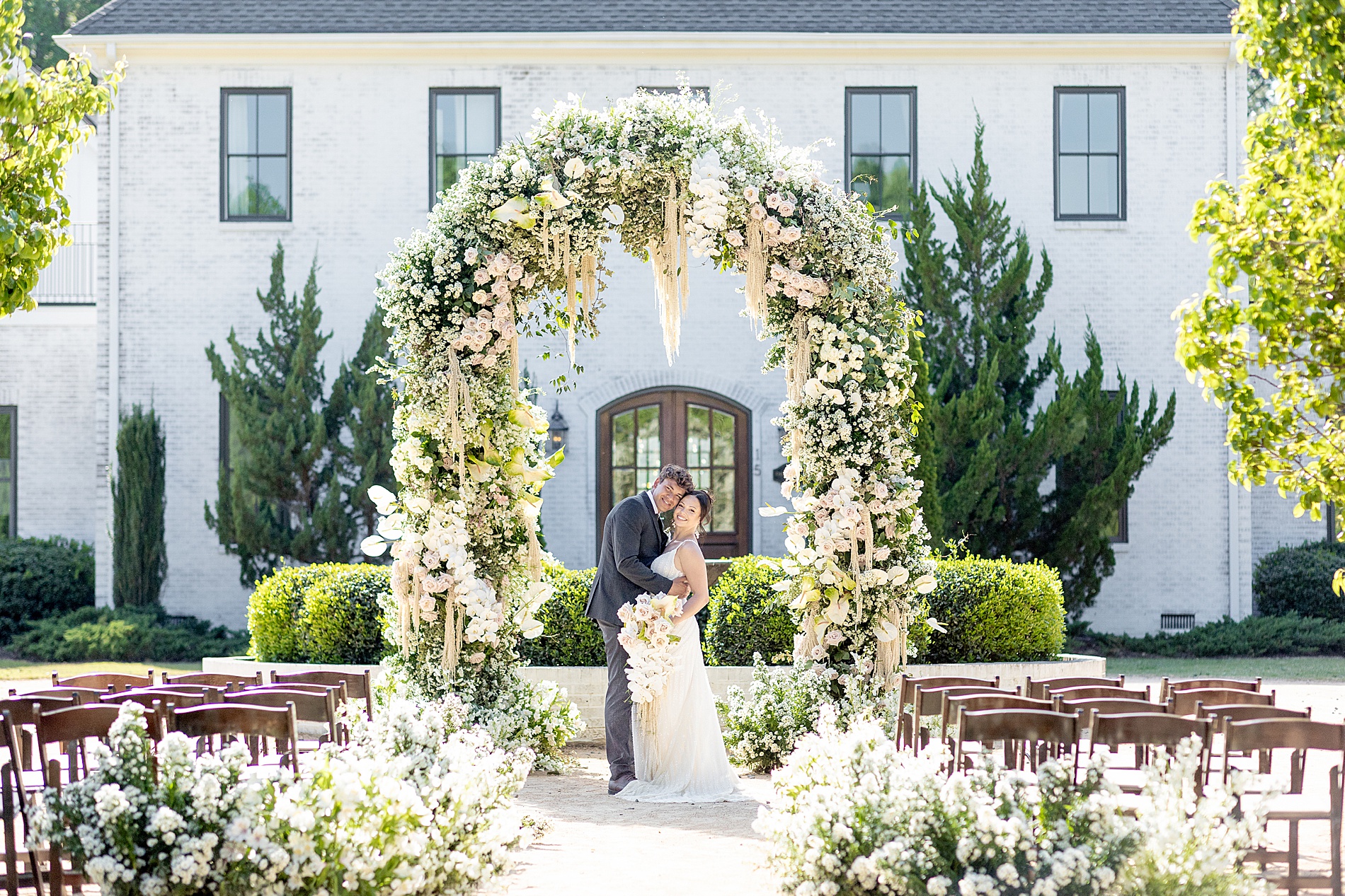 Bride and groom under gorgeous floral arch at The Bradford Luxury Wedding 