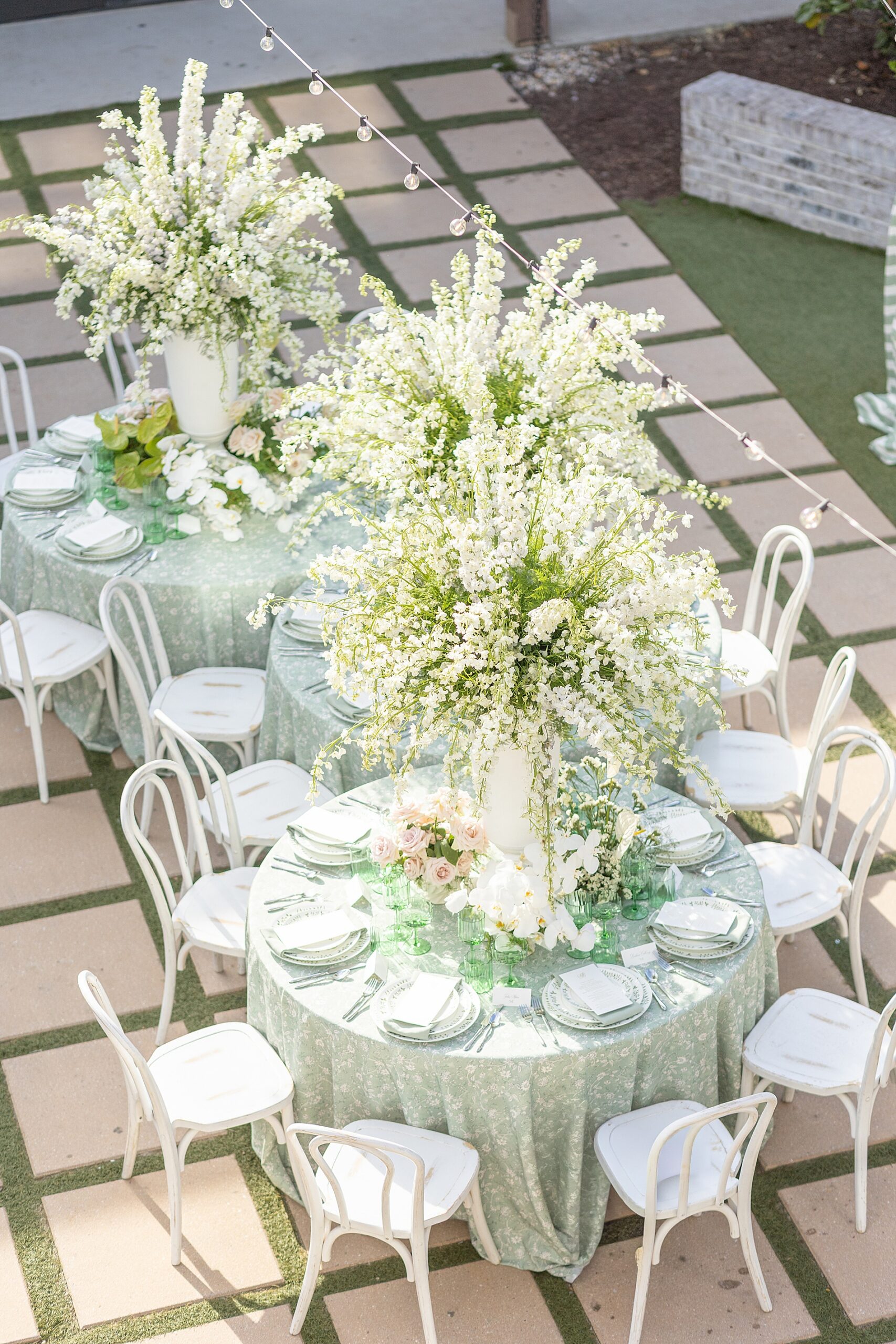 reception tables on patio decorated with tall floral arrangements 