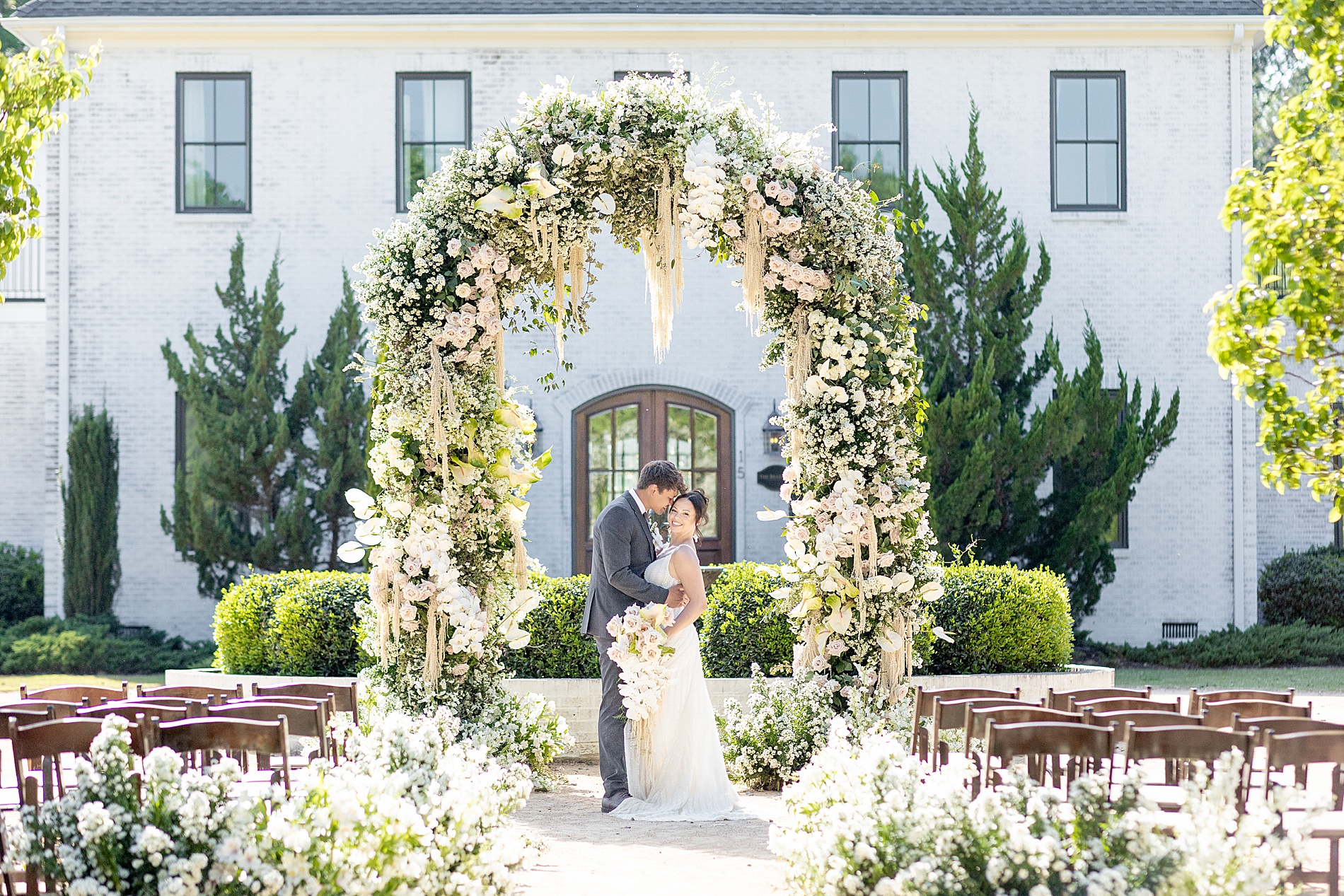 newlyweds under floral arch at The Bradford wedding ceremony 