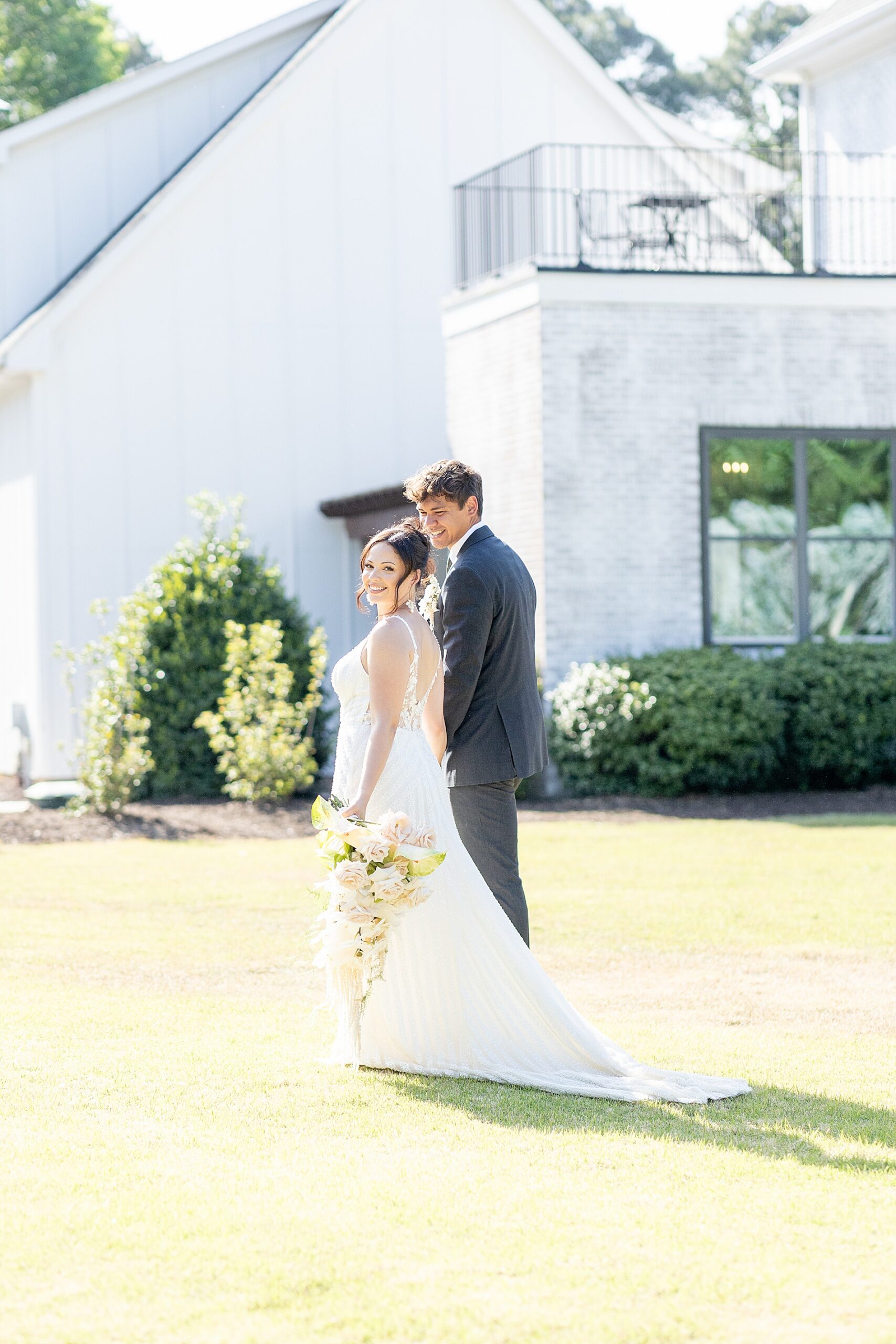 bride and groom walk across property of The Bradford in Raleigh 
