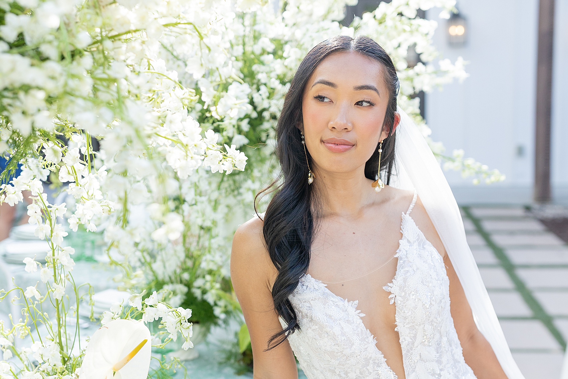 bride sits by floral arrangements