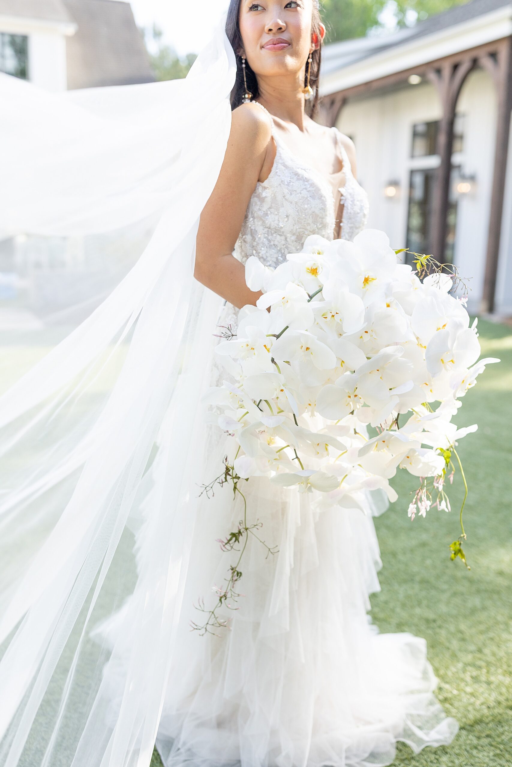 bride walks holding large white lilly bouquet 