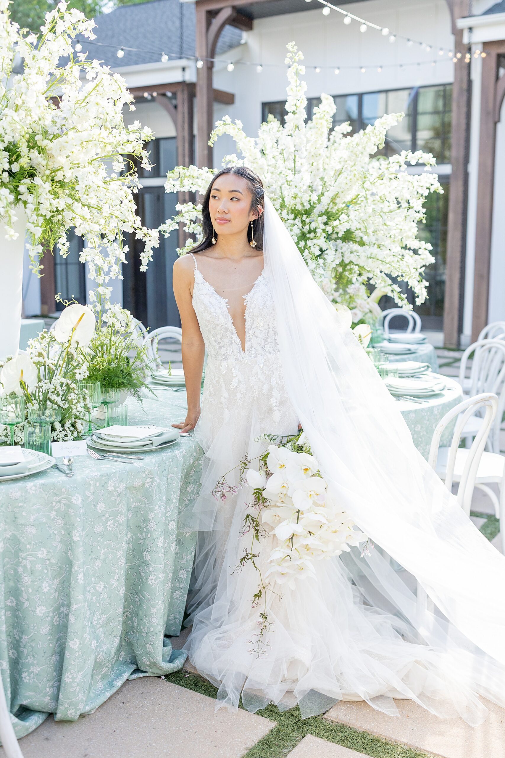 bride sits at reception table elegantly decorated 