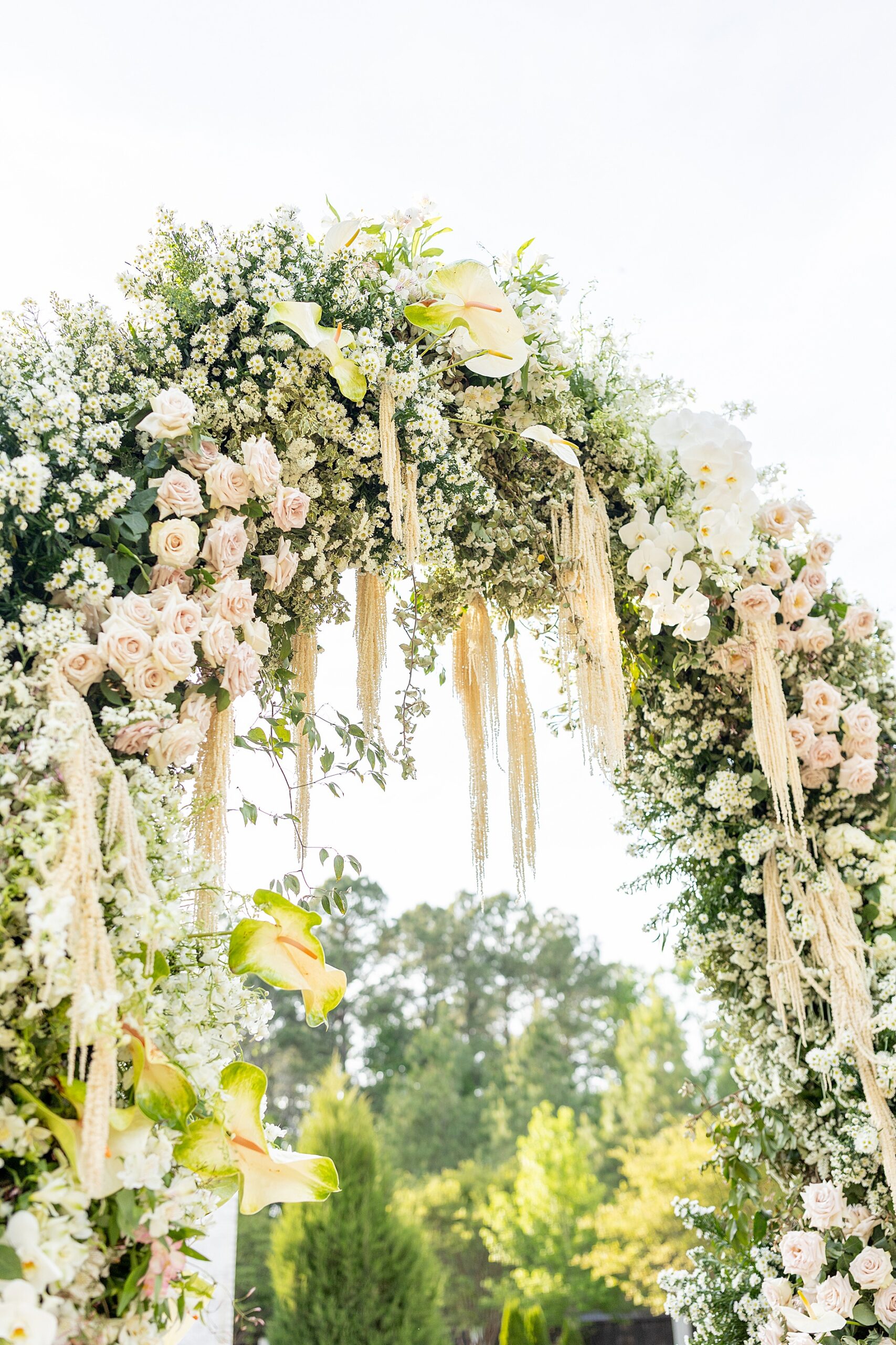 soft florals decorate wedding arch 