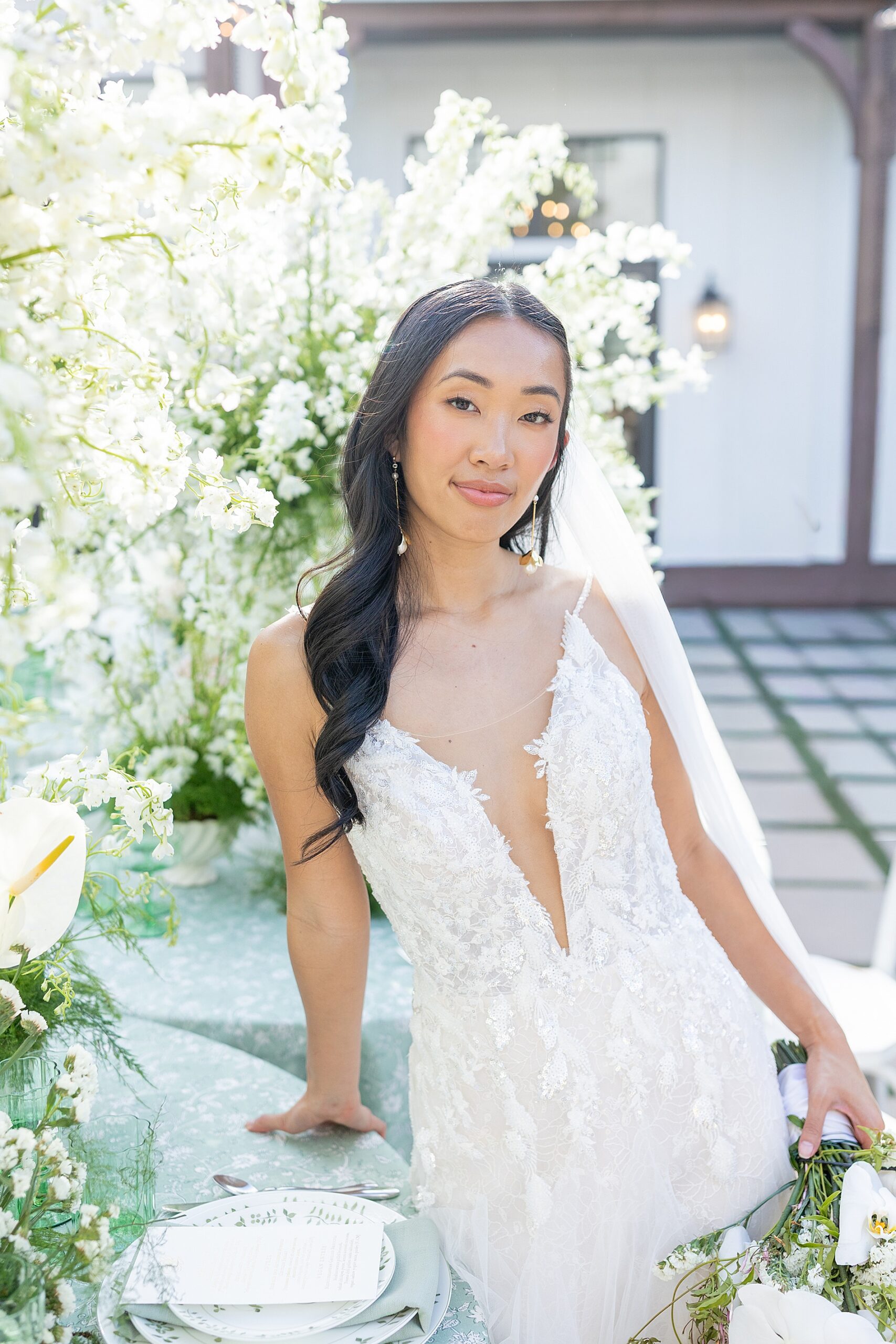 bride in wedding dress by white flowers 